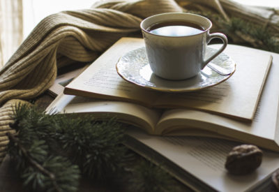 cup-of-tea-on-books-near-scarf