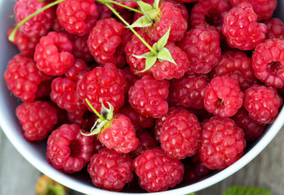 Fresh raspberries in a bowl on a wooden table